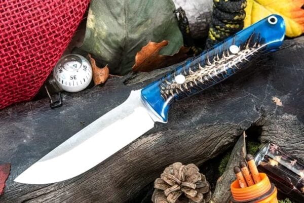 Blue pine cone handle of a cowboy knife showcased in detail.