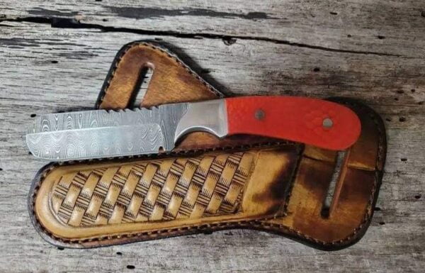 Damascus steel bull cutter knife with red tooled leather sheath.