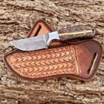 Damascus Cowboy Knife with leather sheath, showcasing hand-forged Damascus steel blade, brass bolsters, and pine cone handle