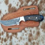 Handmade Damascus Steel Cowboy Knife with raindrop pattern blade, cross draw leather sheath and pine cone handle.