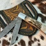 Hand-forged Damascus Trapper Knife featuring a clip blade and spey blade, with a stunning twist pattern and stag antler handle.