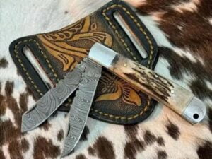 Hand-forged Damascus Trapper Knife featuring a clip blade and spey blade, with a stunning twist pattern and stag antler handle.