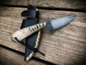 Handmade carbon steel cowboy knife with a drop point blade and sheep horn handle.