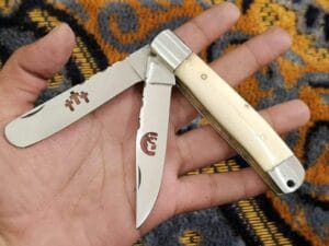 Double-Folding Trapper Knife with Camel Bone Handle and leather sheath.