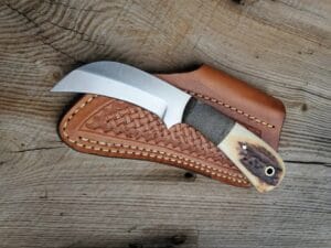 D2 hawksbill knife with Stag antler handle and leather sheath.