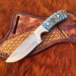 Rasp steel cowboy hunting knife with pancake leather sheath and pine cone handle.